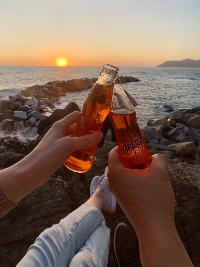 Cheers! Aperol Spritz at sunset in Riomaggiore, Cinque Terre, Italy